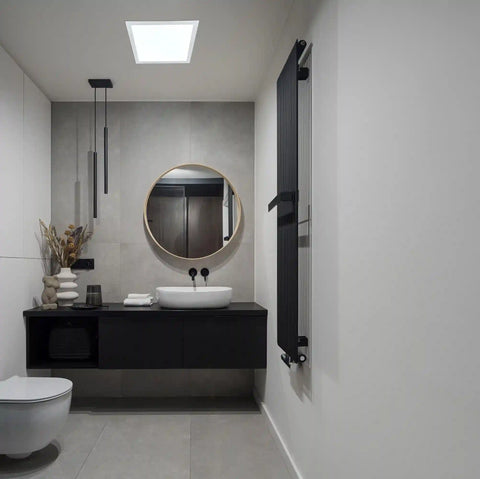 Modern bathroom with black vanity, round mirror, and solar light.