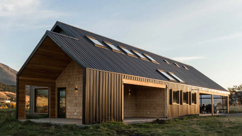 Modern house with a sloped roof and wooden exterior with roof windows.